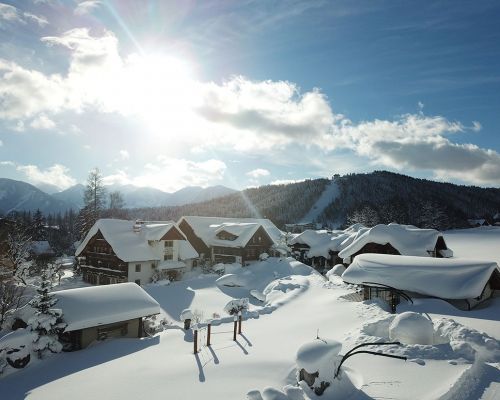 Luftaufnahme über der winterlichen Landschaft vom Urlaubsdorf Bio-Bauernhof Simonbauer mit Apartments, Ferienhaus, Penthaus und Zimmer in Ramsau am Dachstein